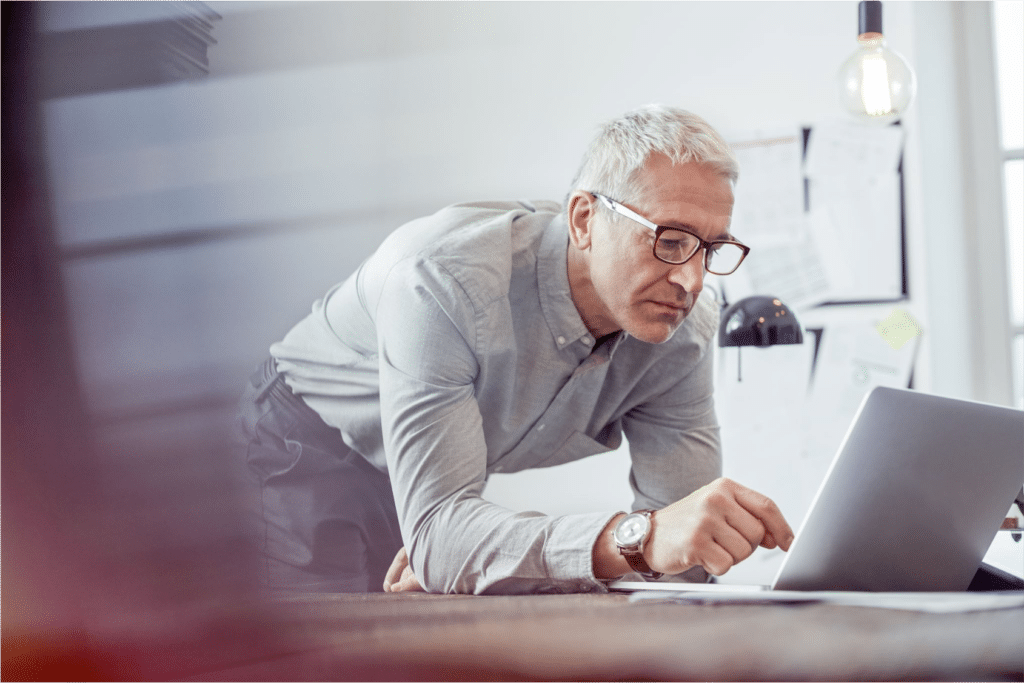 Picture shows a man at his laptop sending a group message.