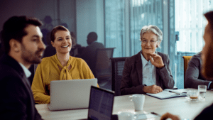 Picture of people engaging in person at an office meeting.