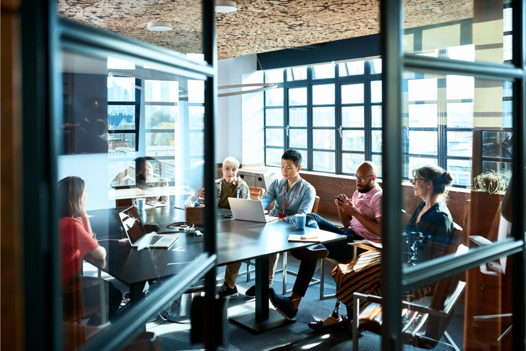 Image shows a hybrid in-person and virtual meeting.