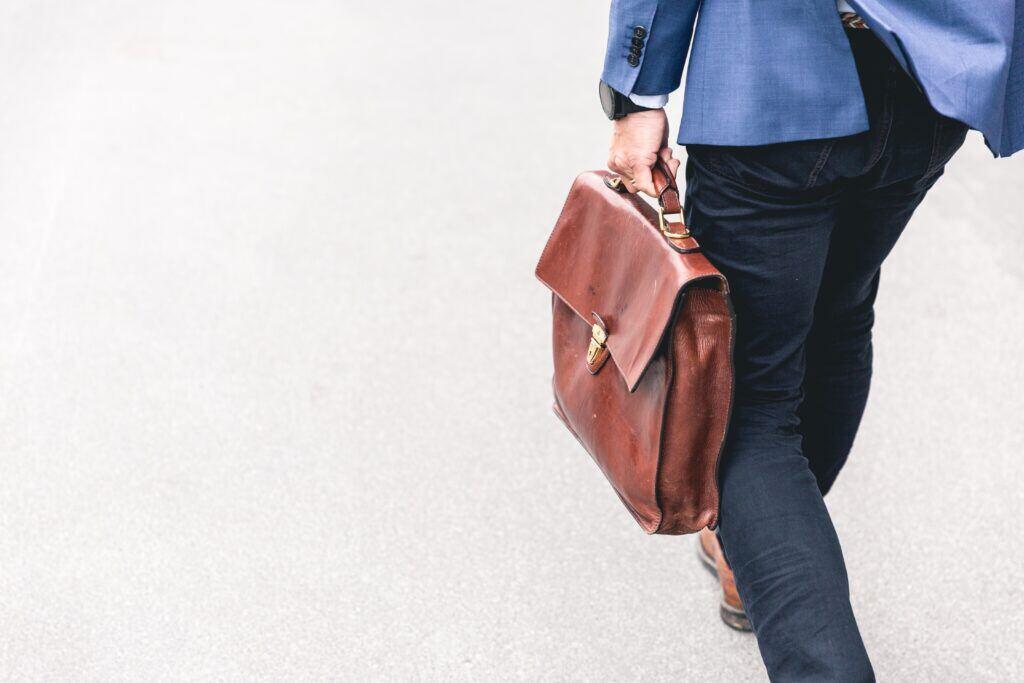 Will robots take away human jobs? That's not what it looks like in this image of a man walking with his briefcase.
