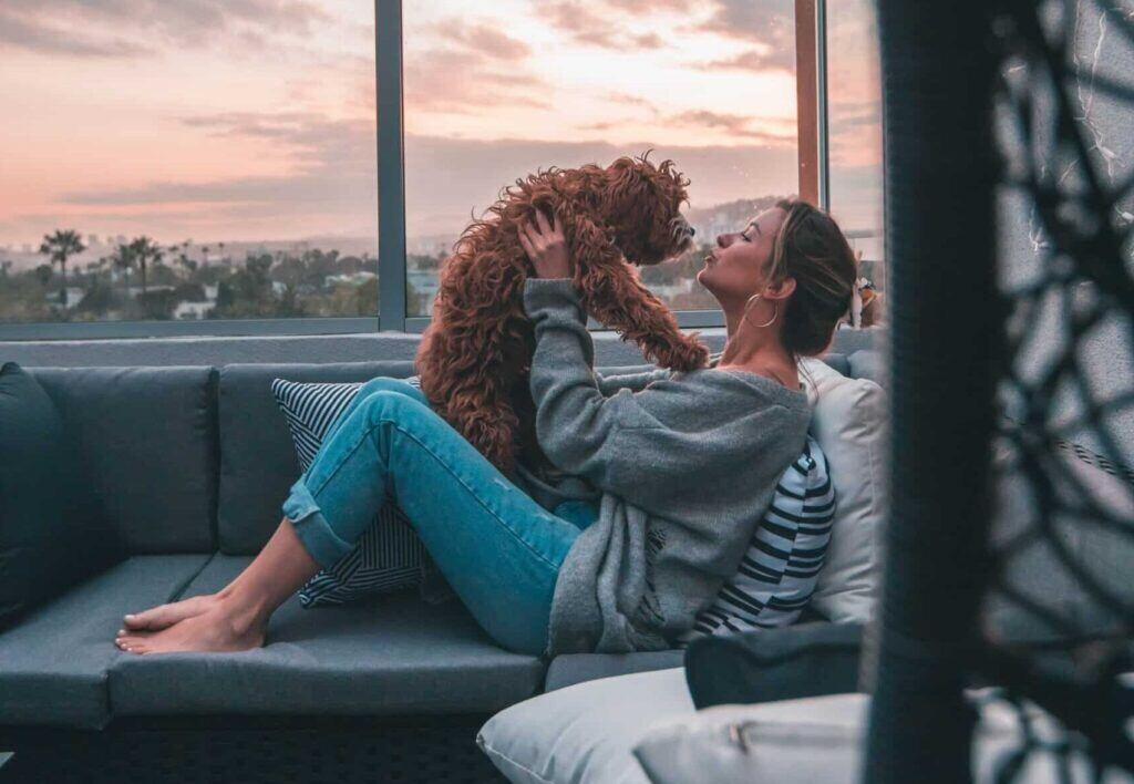 Photo of a woman relaxing with her dog, a bond she might share with her teammates on Microsoft Viva Engage.
