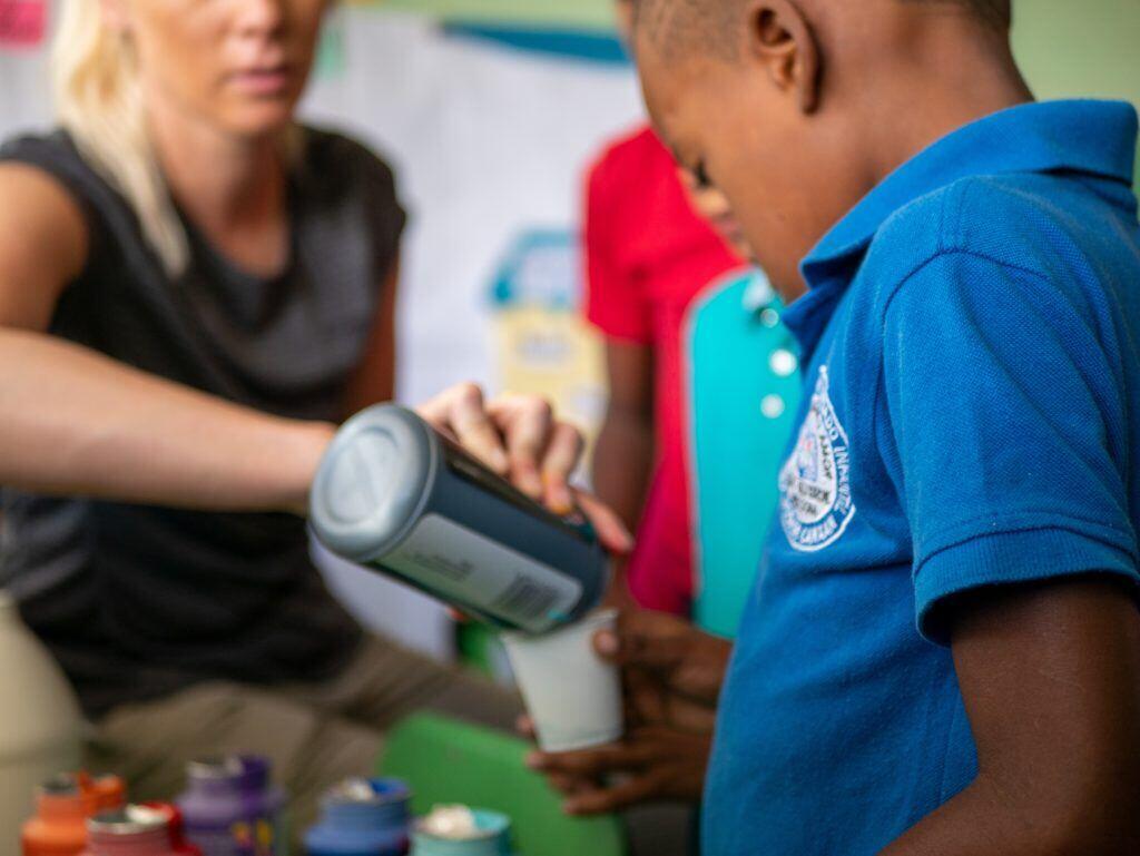 Image shows a nonprofit volunteer working with children.