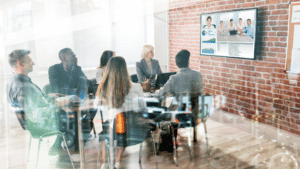 A photo of a group of workers on a conference call with remote employees.