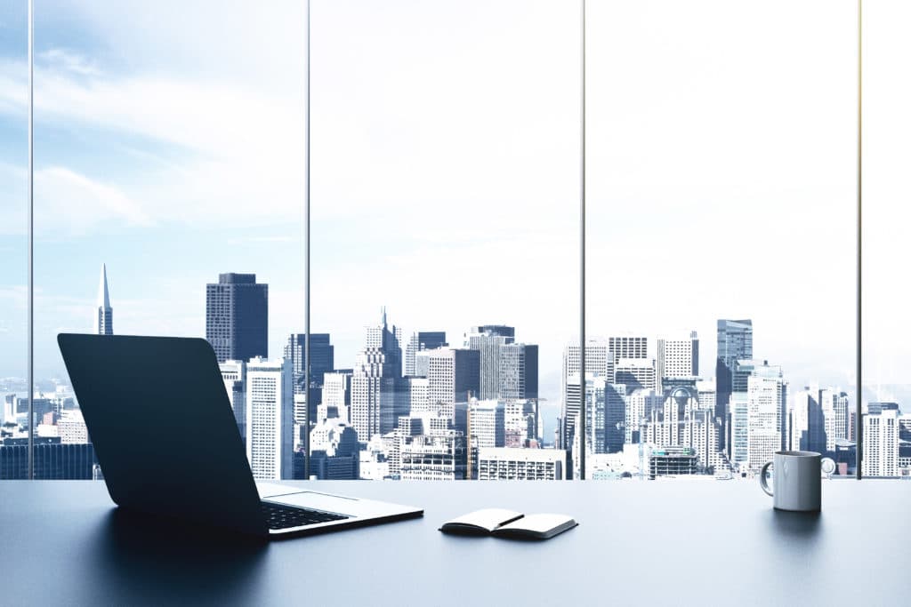 Image shows business workspace with laptop and notebook.