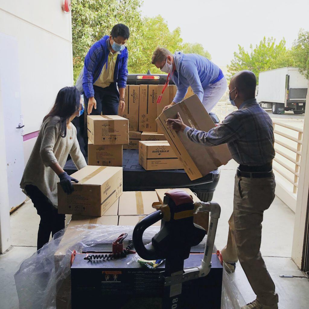 Picture shows masked workers getting delivery boxes ready for shipment.