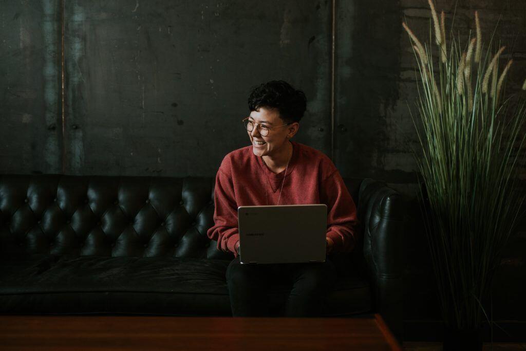 Photo of a happy customer engaging with an organization on her laptop.