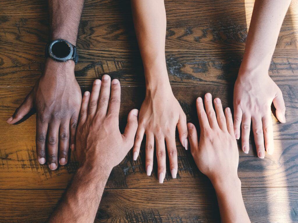 Picture shows people's hands of various colors and sizes.