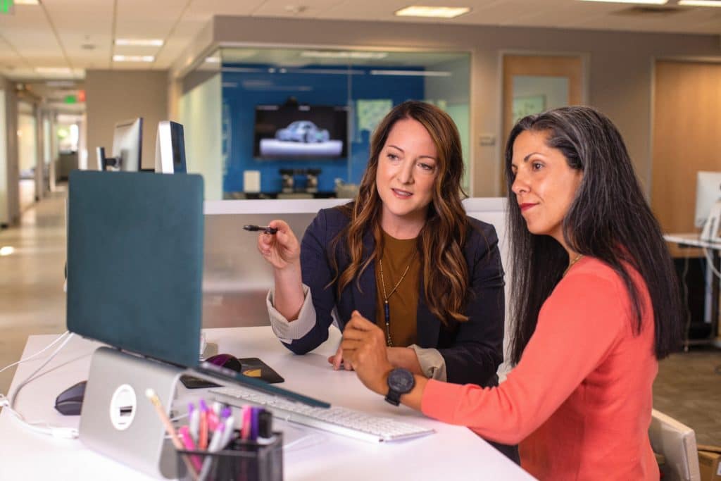 Women on an MSSP team discuss security monitoring for an organization.
