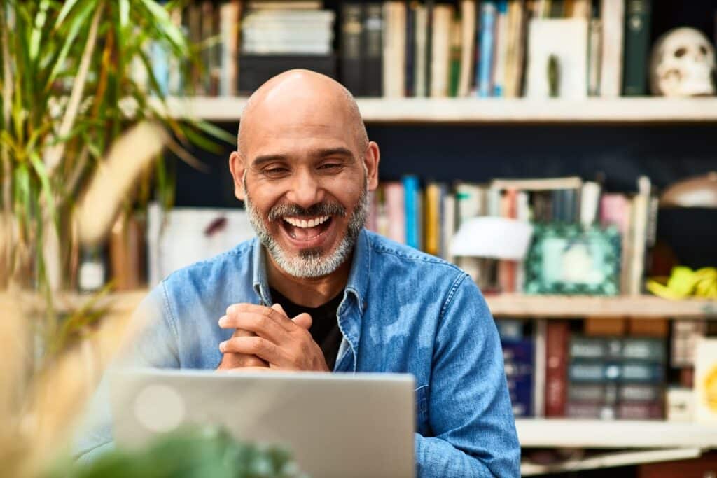 Image of a man laughing shows one of the many ChatGPT use cases: entertainment.