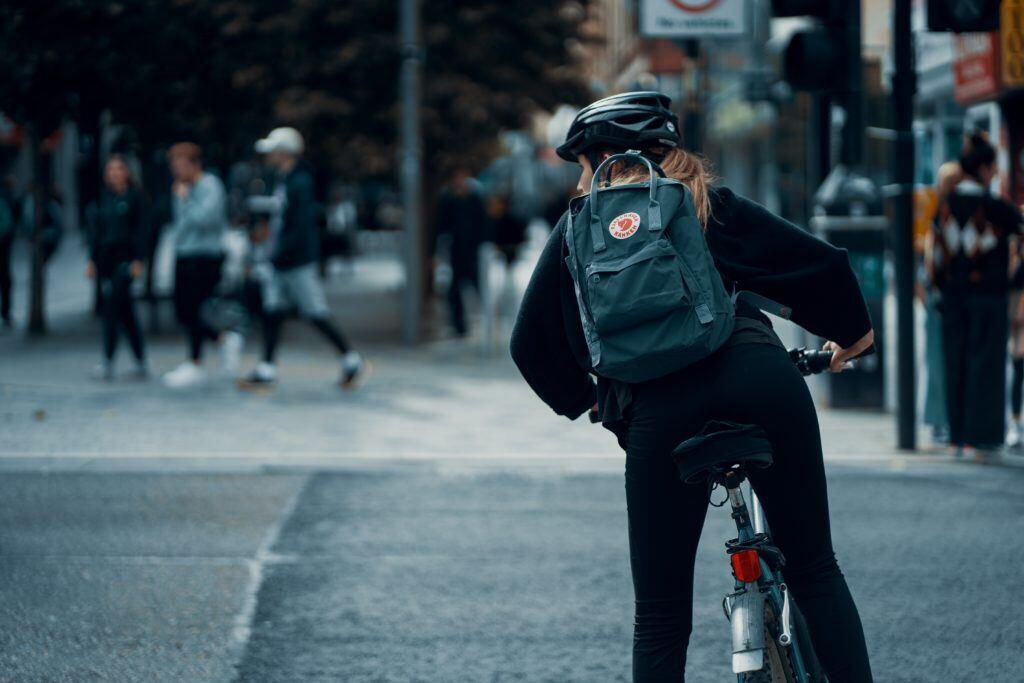 A bicyclist looks around to safely navigate the road.